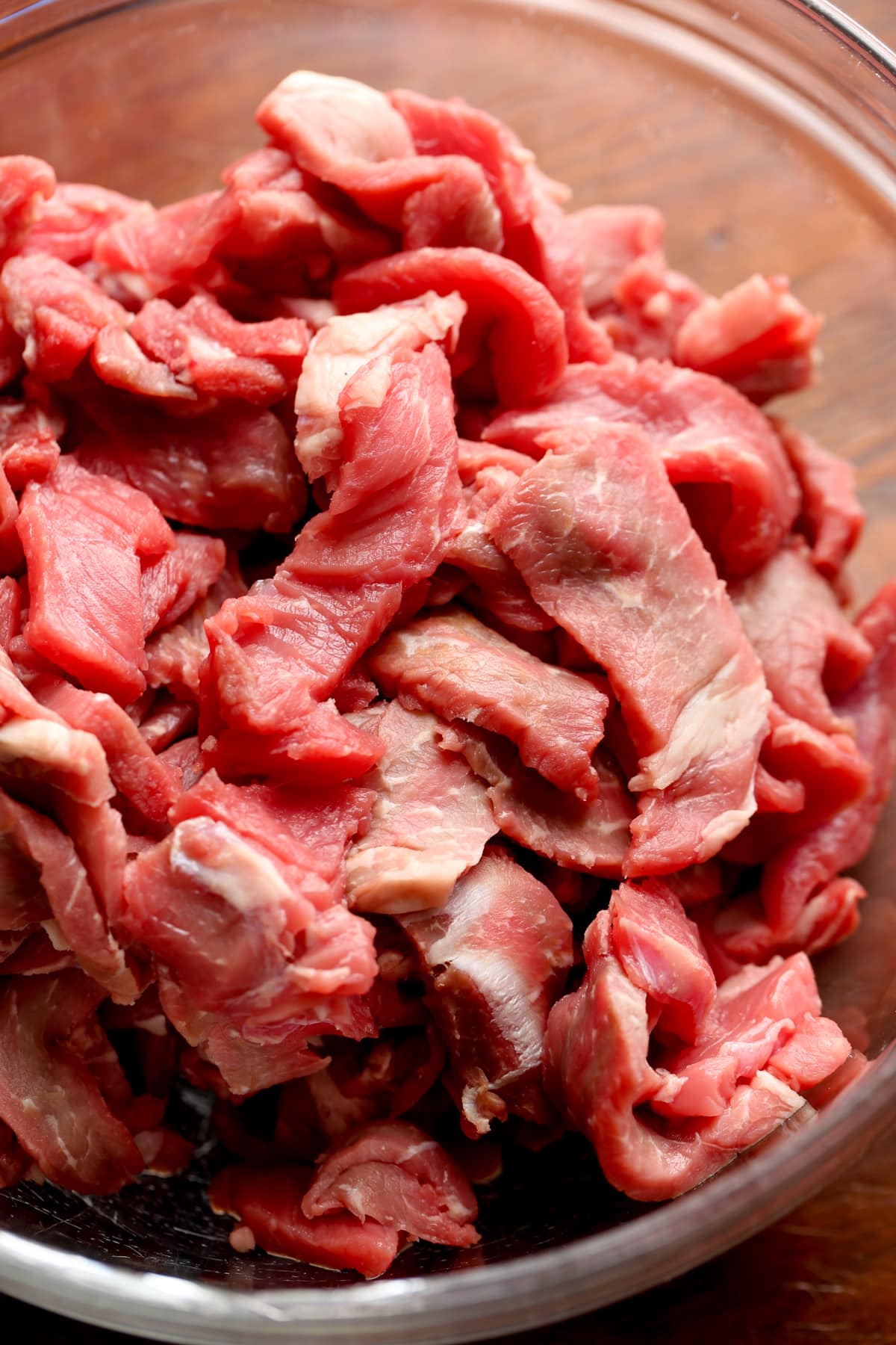 Raw steak slices in a bowl.