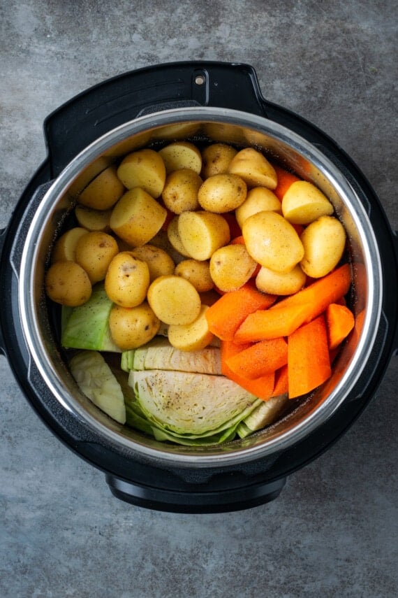 Potatoes, carrots, and cabbage added to the instant pot with corned beef.