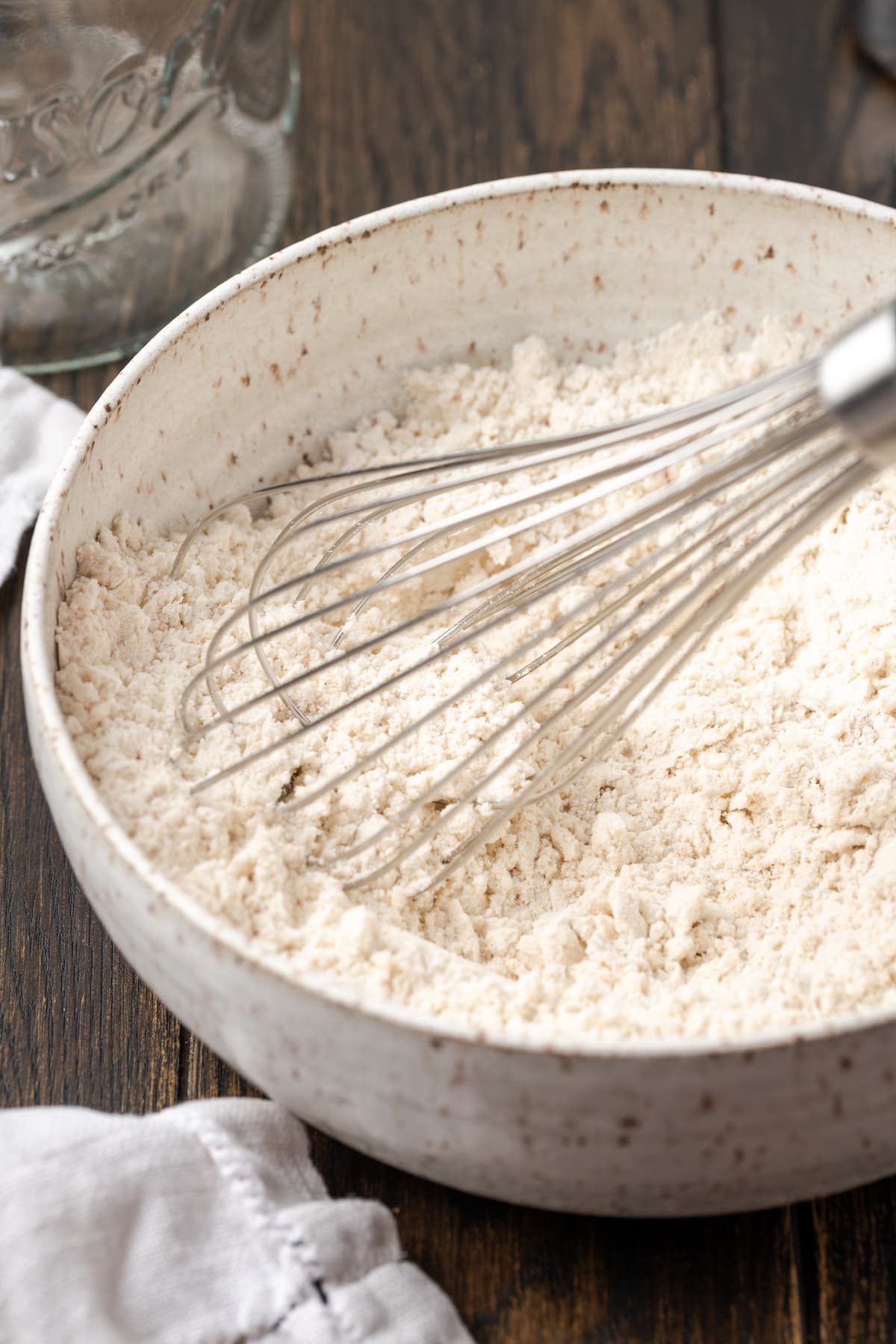 Self rising flour in a bowl with a whisk.