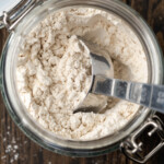 Overhead view of self rising flour in a mason jar with a measuring spoon.