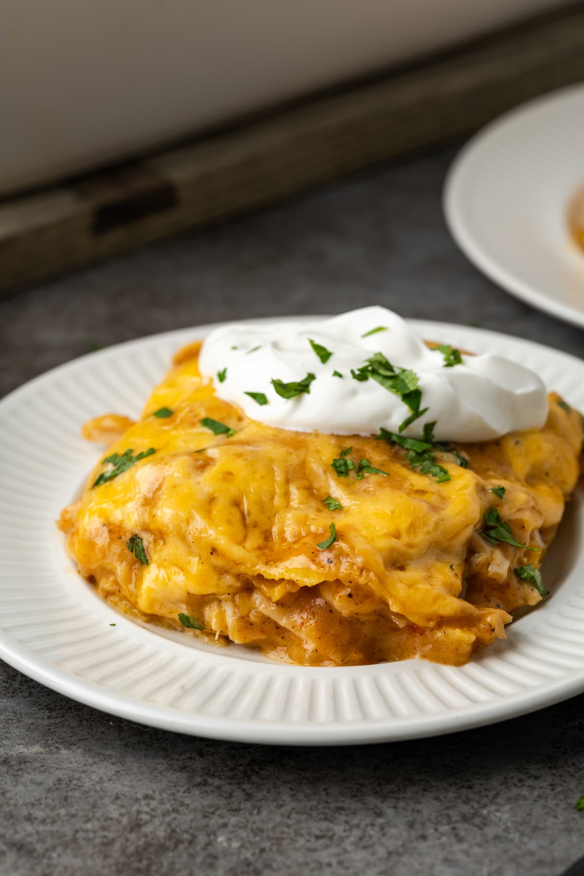 A serving of King Ranch chicken topped with sour cream on a plate.