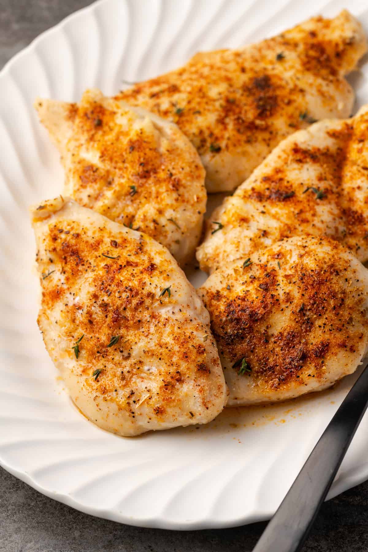 Baked chicken breasts on a large white platter.