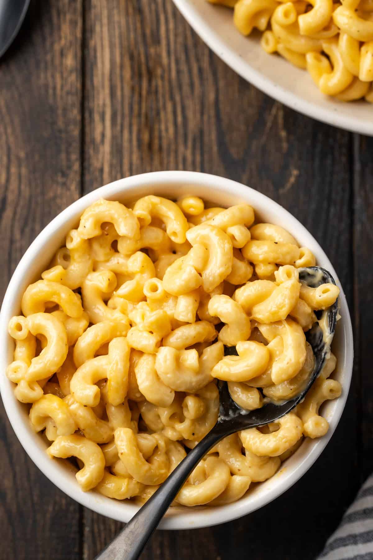 Overhead view of a bowl of mac and cheese with a spoon.