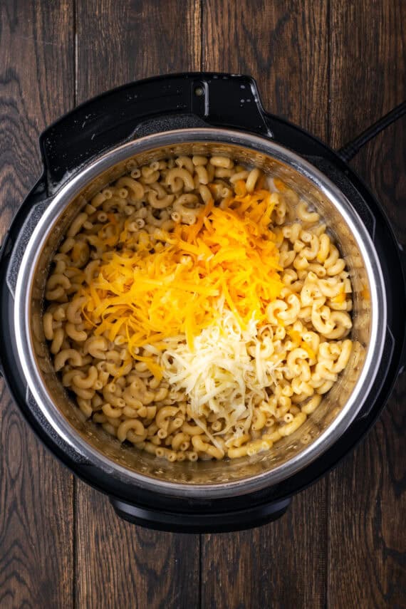 Shrredded cheese added to cooked macaroni inside the Instant Pot.