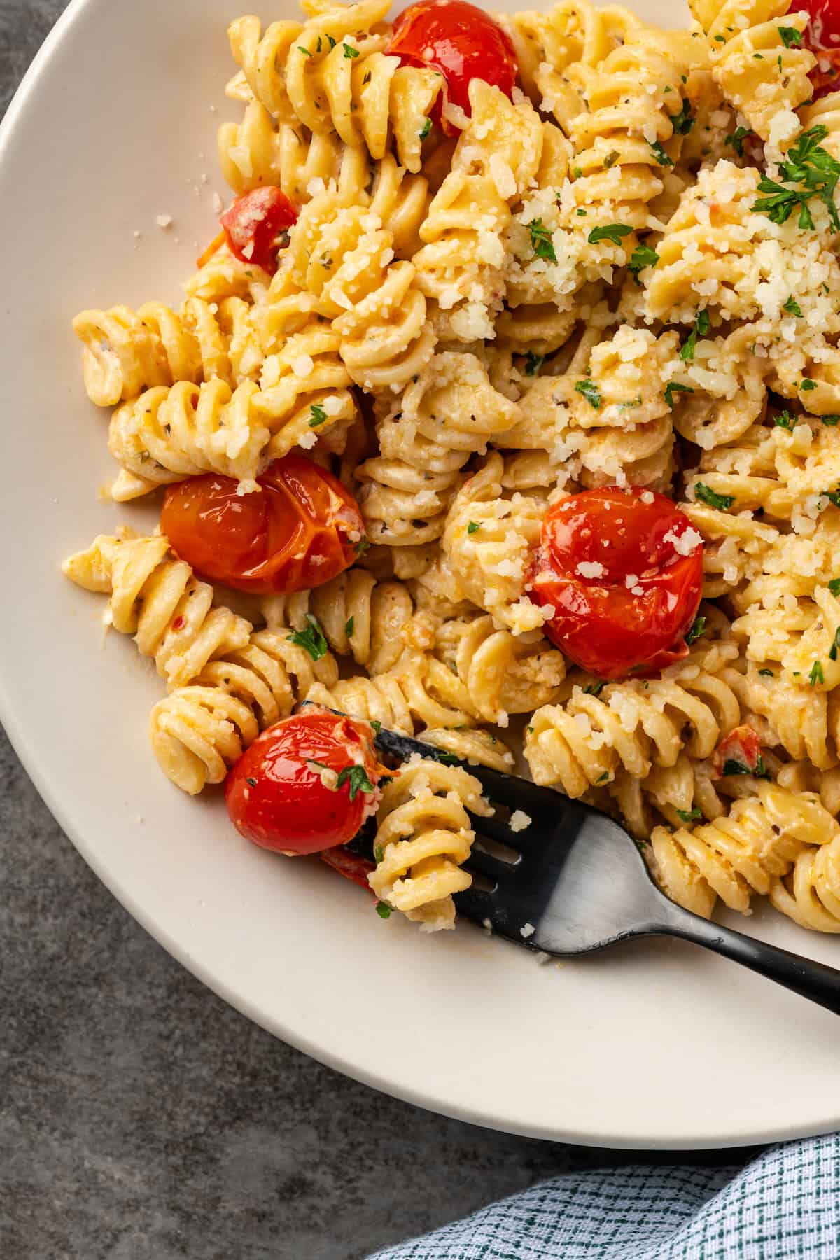 Overhead view of a fork resting on a plate of pasta with Boursin cheese.