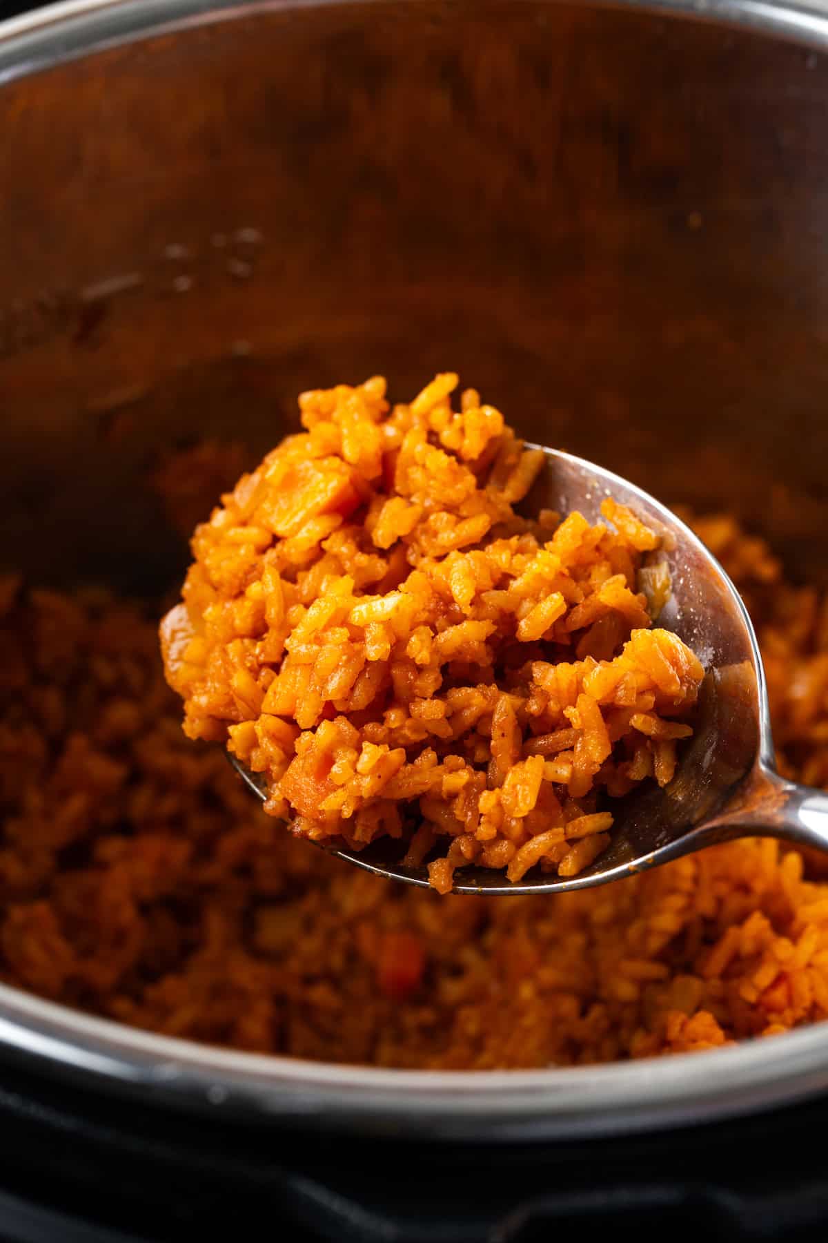 Close up of a spoonful of Mexican rice held over the Instant Pot.