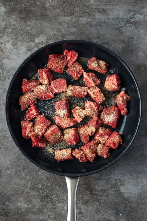 Brown the cubed beef in a skillet.