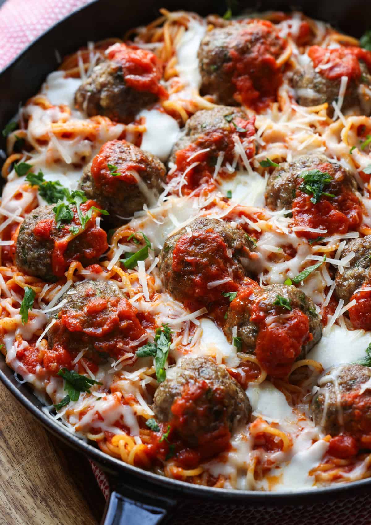 Baked spaghetti topped with cheese, sauce and meatballs.