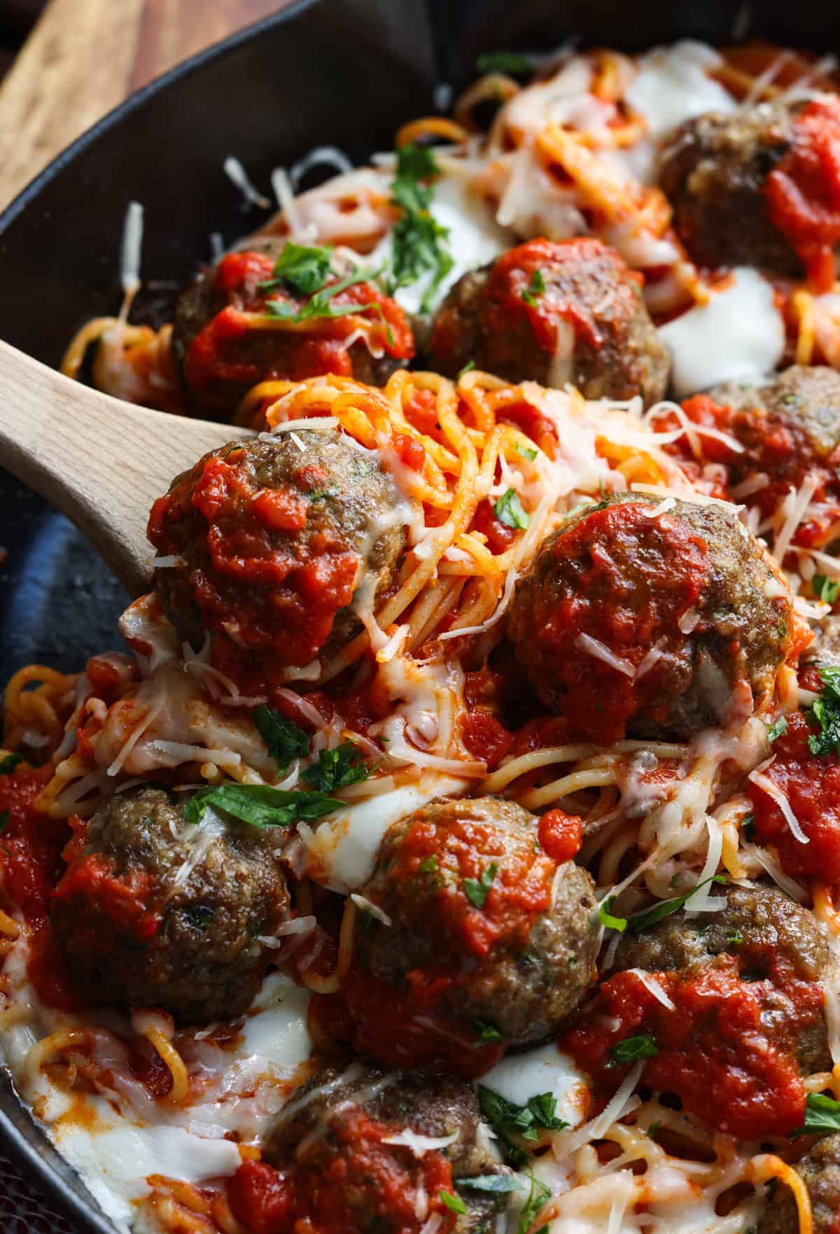 A spoon serving a scoop of spaghetti and meatballs