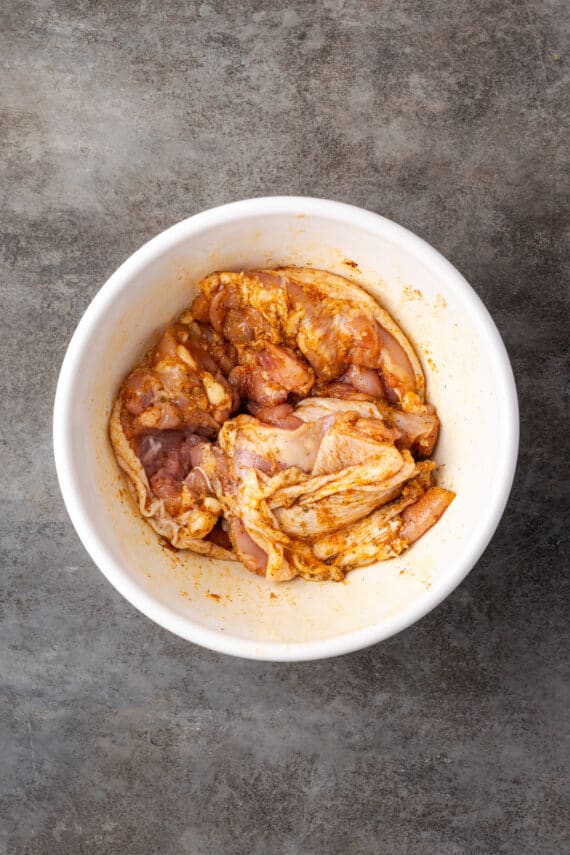 Marinate chicken thighs in a large bowl.