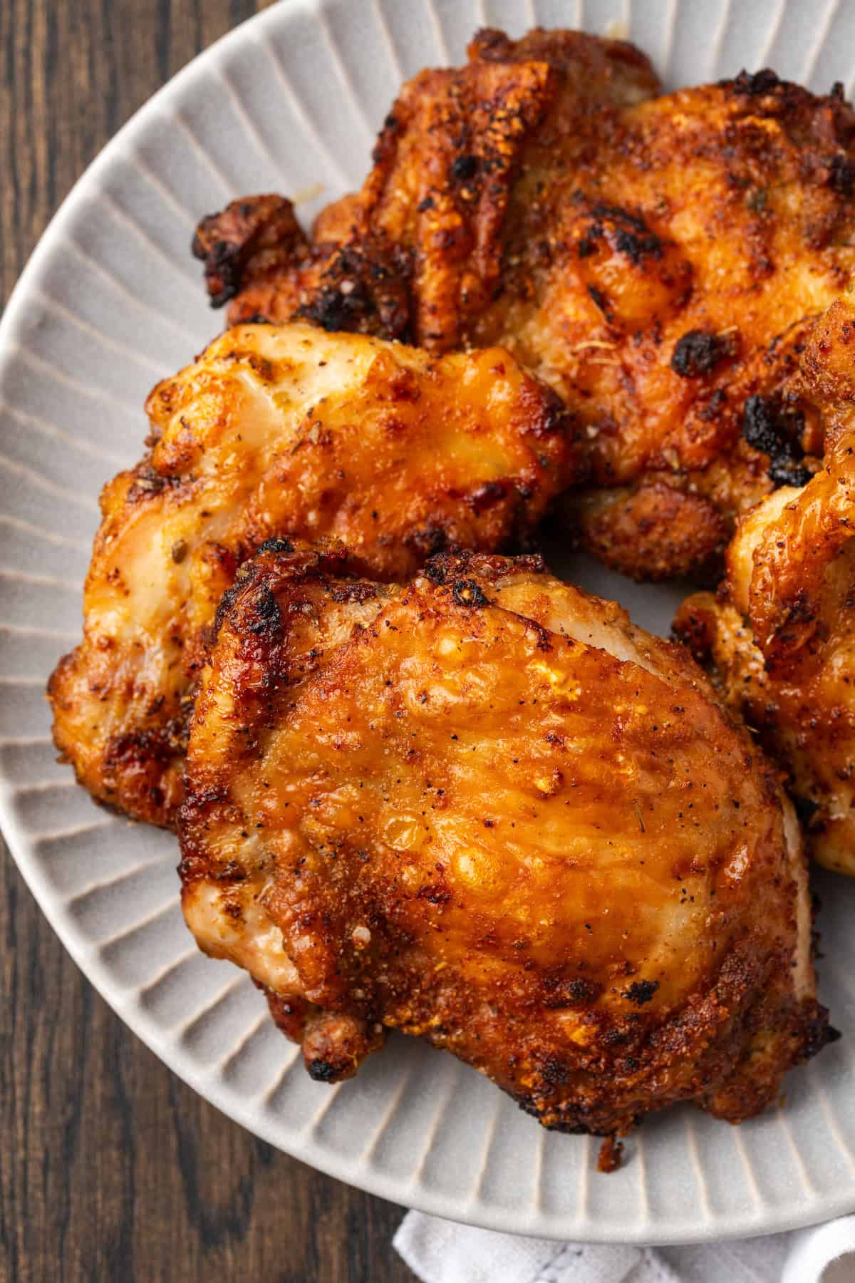 Close up of air fryer chicken thighs on a platter.