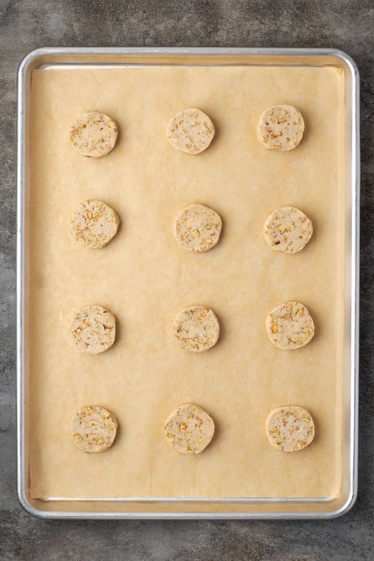 Pecan sandies are buttery, crumbly shortbread cookies with crispy edges and plenty of nutty crunch. They make great Christmas cookies! Rows of pecan sandies cookies on a parchment-lined baking sheet.