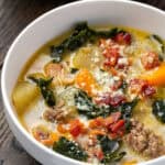 Zuppa Toscana served in a white bowl, with a second bowl of soup in the background.