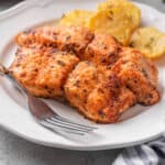 Cooked air fryer salmon on a plate with a fork.