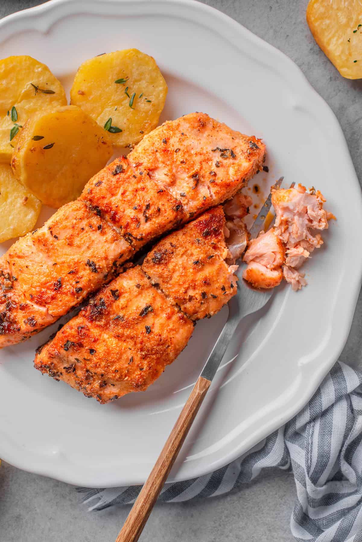 Air fryer salmon on a plate with a bite taken out.