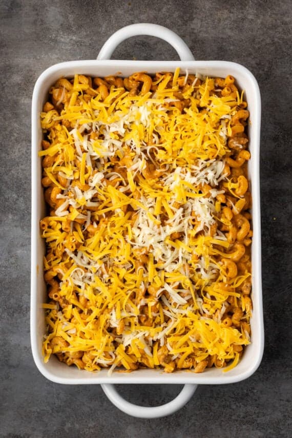 Cheeseburger casserole topped with cheese in a large ceramic casserole dish.