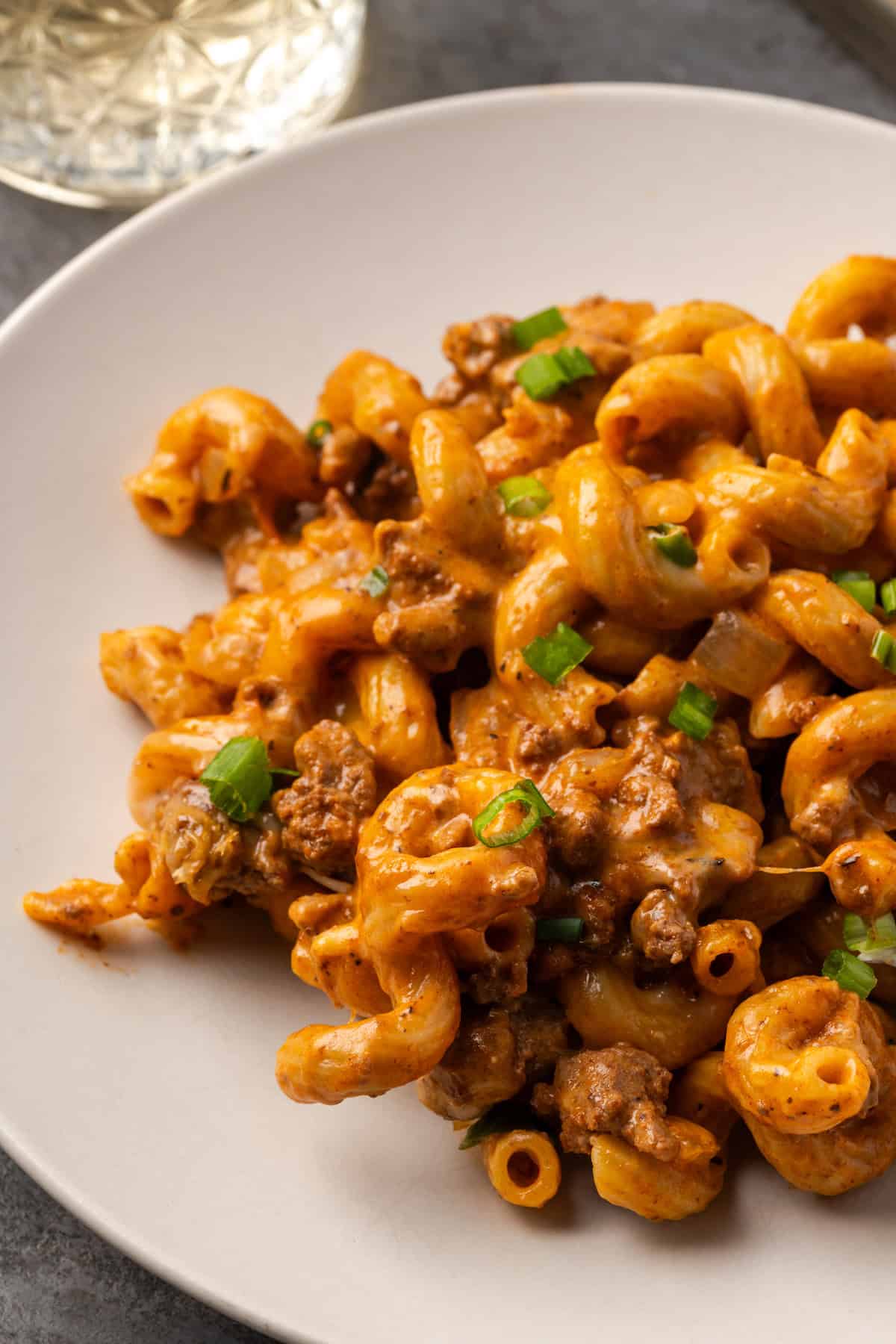 A serving of cheeseburger casserole on a white plate.