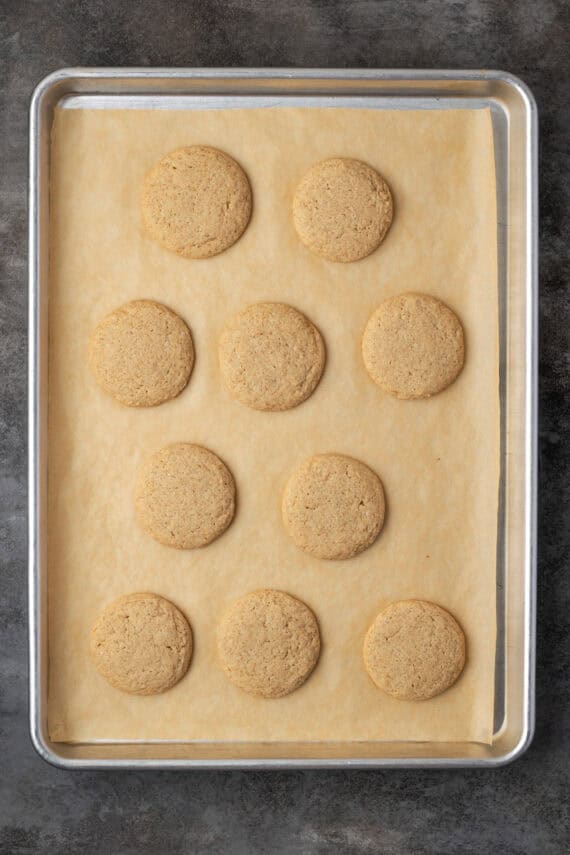 Baked chai sugar cookies on a parchment-lined baking sheet.