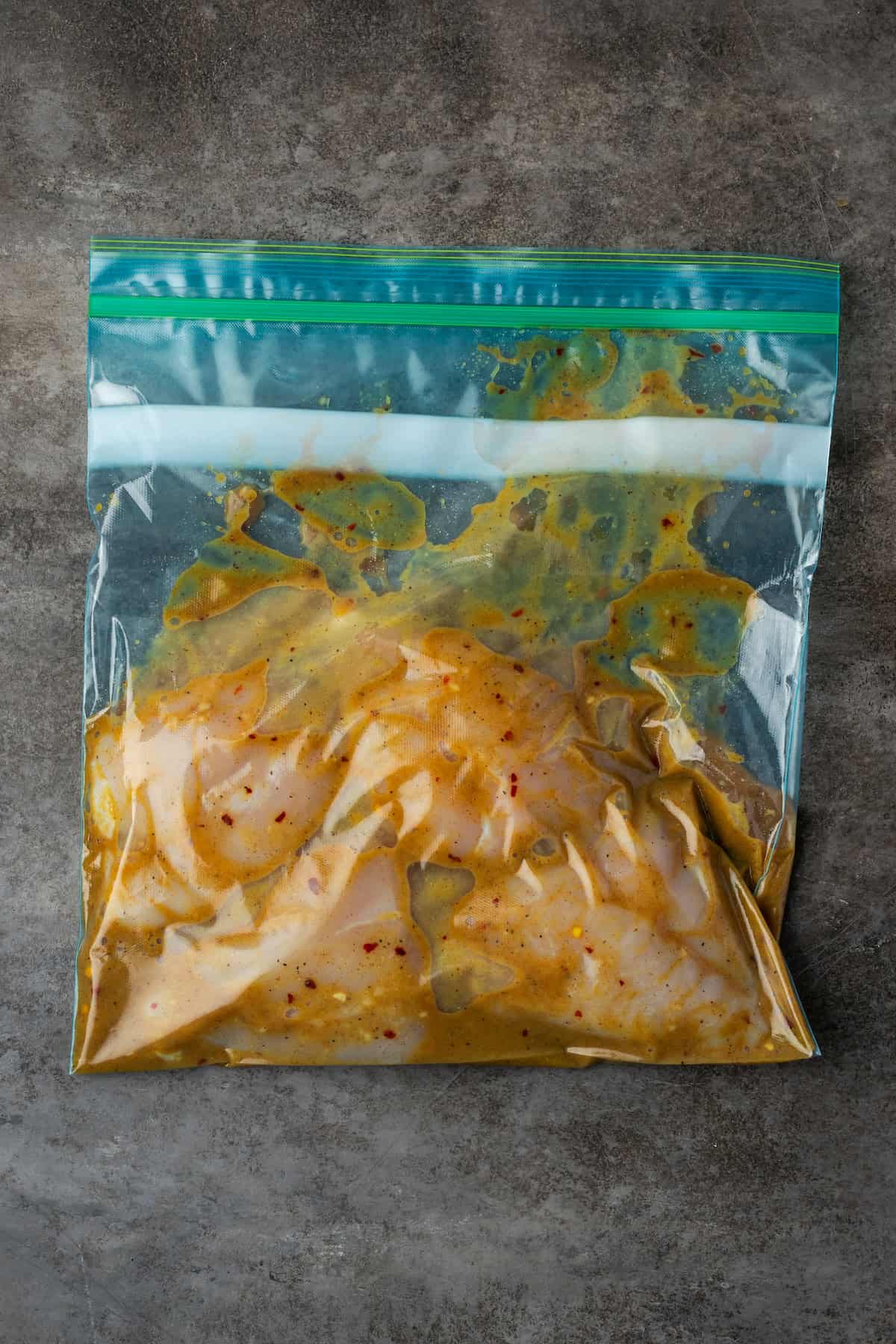 Chicken breasts marinating in a ziploc bag with honey mustard sauce.