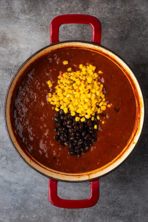 Corn and beans added to a pot of chili con carne.
