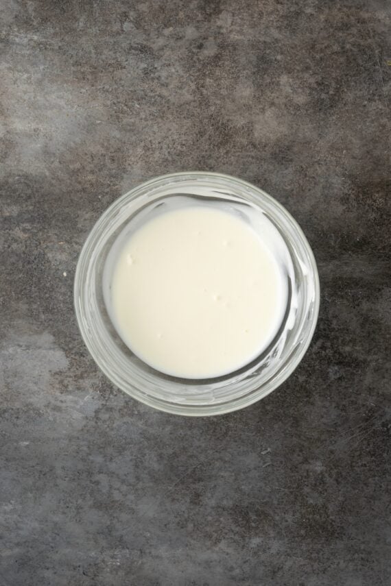 Cream cheese glaze in a glass bowl.