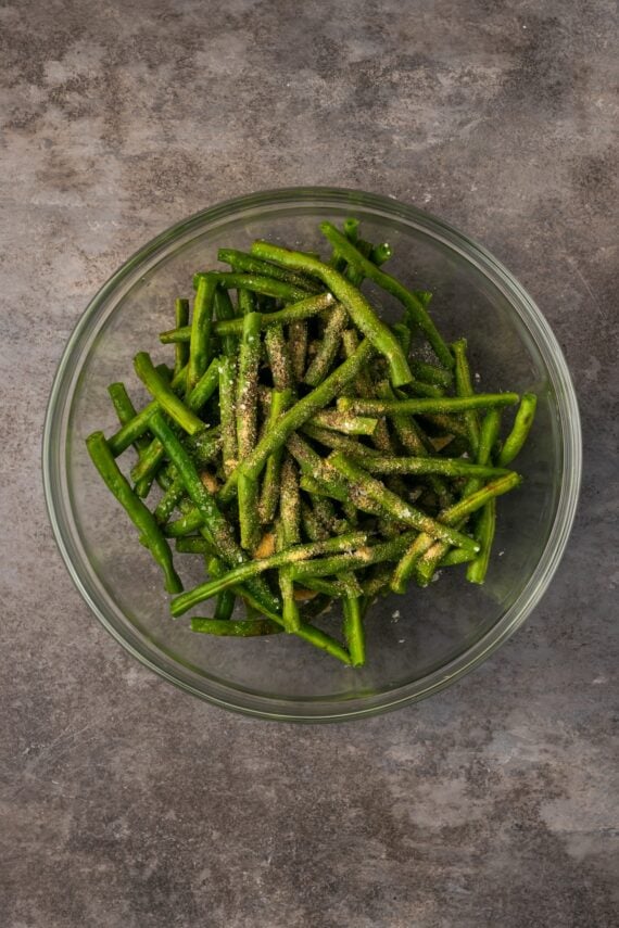 Seasonings added to a bowl of green beans.