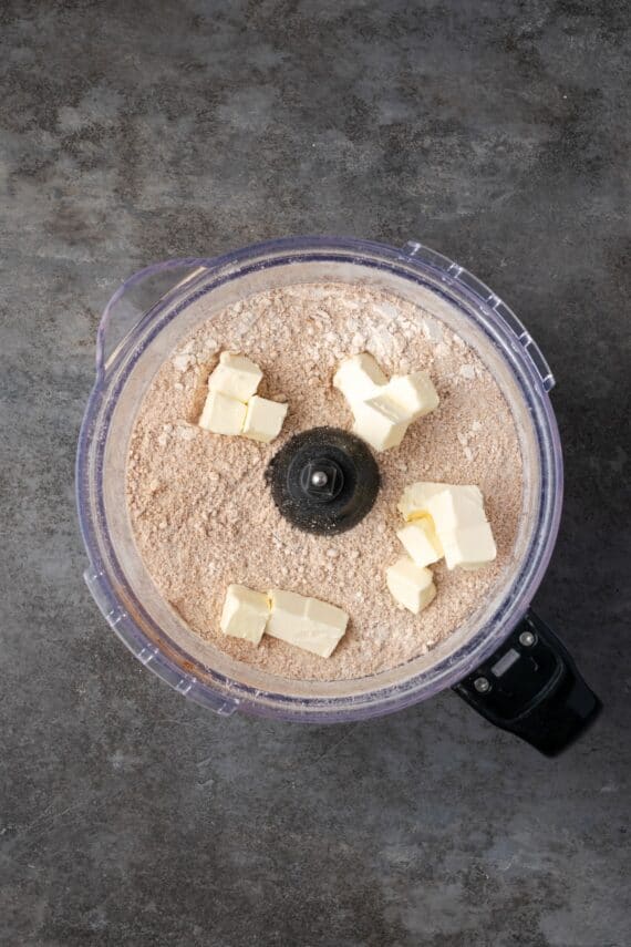 Cold cubed butter added to the crumble ingredients in a food processor.