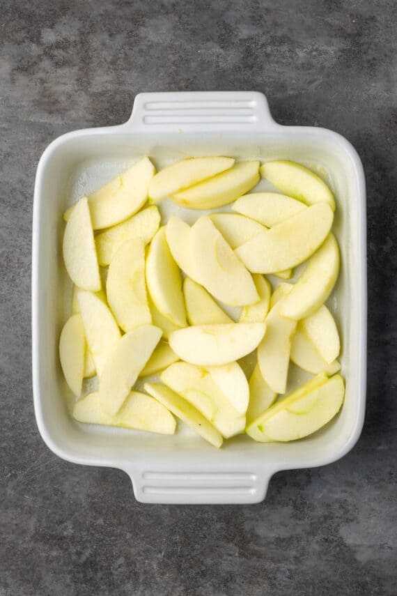 Apple slices in the bottom of a baking dish.