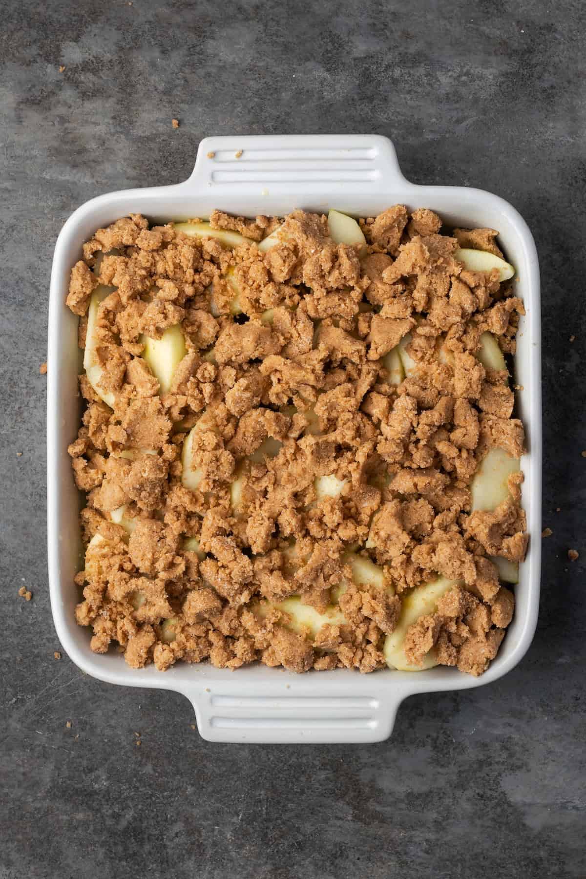 This easy apple brown betty is an old-fashioned dessert recipe with gooey baked apples layered with a buttery, sweet cinnamon crumble. Crumble layered with apple slices in a baking dish.