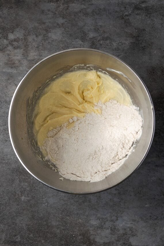Dry ingredients added to wet cake ingredients in a bowl.