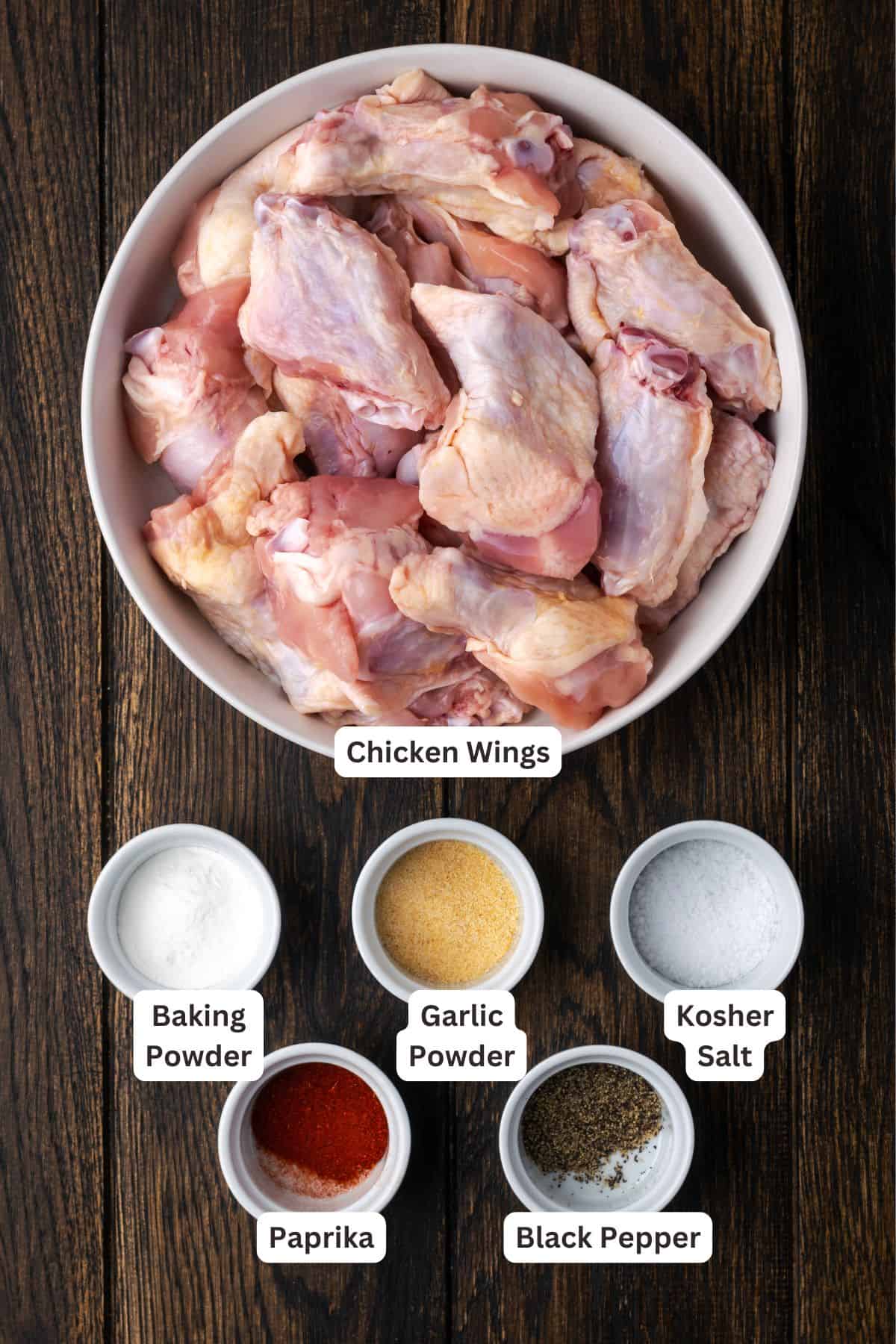Raw chicken wings and seasonings in bowls.