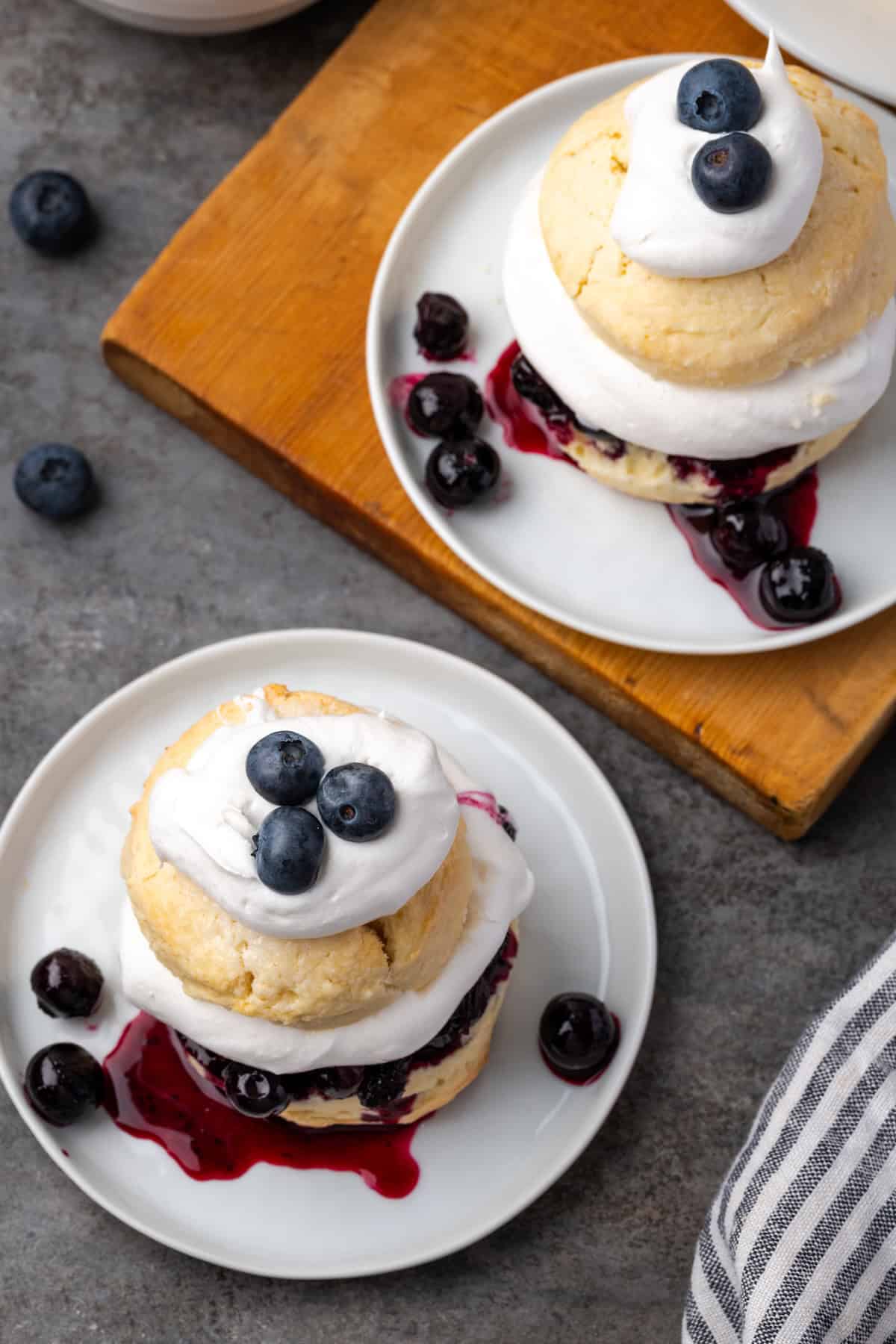 Overhead view of two servings of blueberry shortcake on plates.