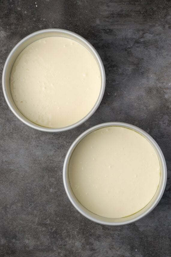 This red velvet cheesecake has four decadent layers of creamy cheesecake and soft red velvet cake smothered with cream cheese frosting. Two round pans filled with cheesecake batter.