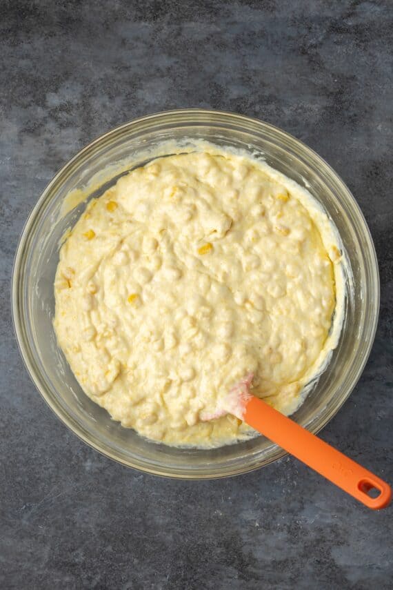 Spoon bread batter in a bowl with a spoon.