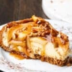 A slice of apple cheesecake covered with caramel sauce on a plate.
