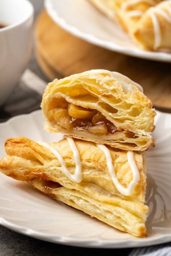 Two halves of an apple turnover stacked on a plate.
