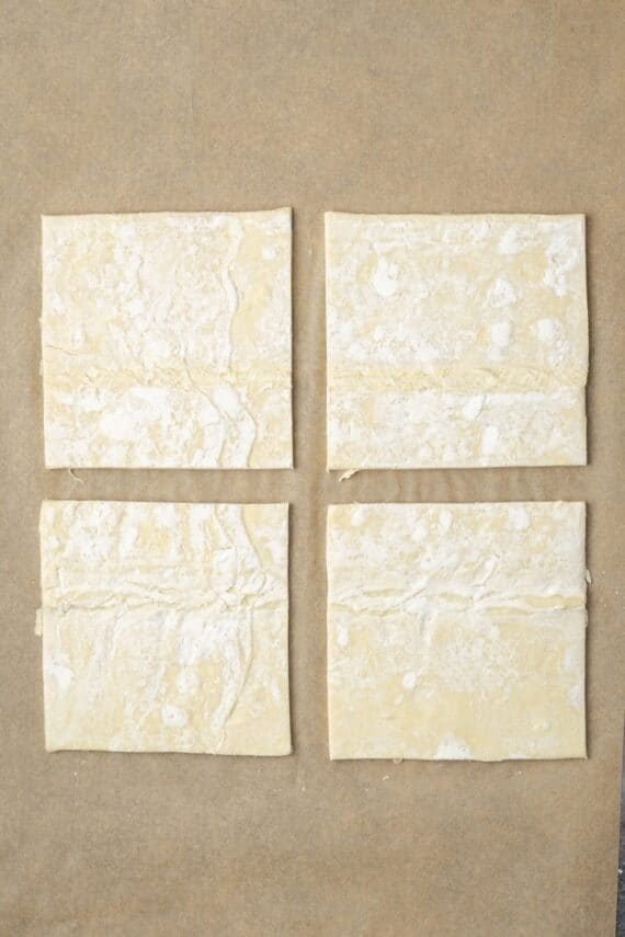 Crispy, buttery store-bought puff pastry and quick, homemade apple filling make these easy apple turnovers the perfect fall weekend treat! A sheet of puff pastry cut into four squares on a piece of parchment paper.