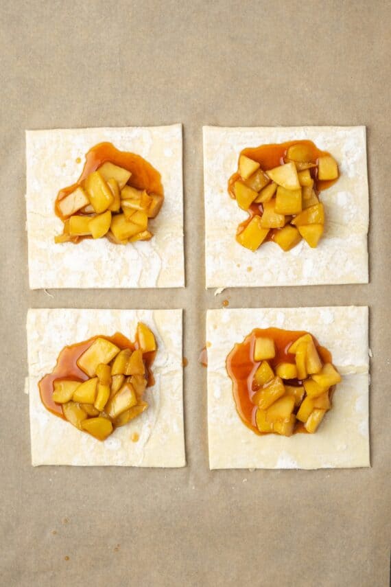 Crispy, buttery store-bought puff pastry and quick, homemade apple filling make these easy apple turnovers the perfect fall weekend treat! Apple filling added to the centers of four puff pastry squares.