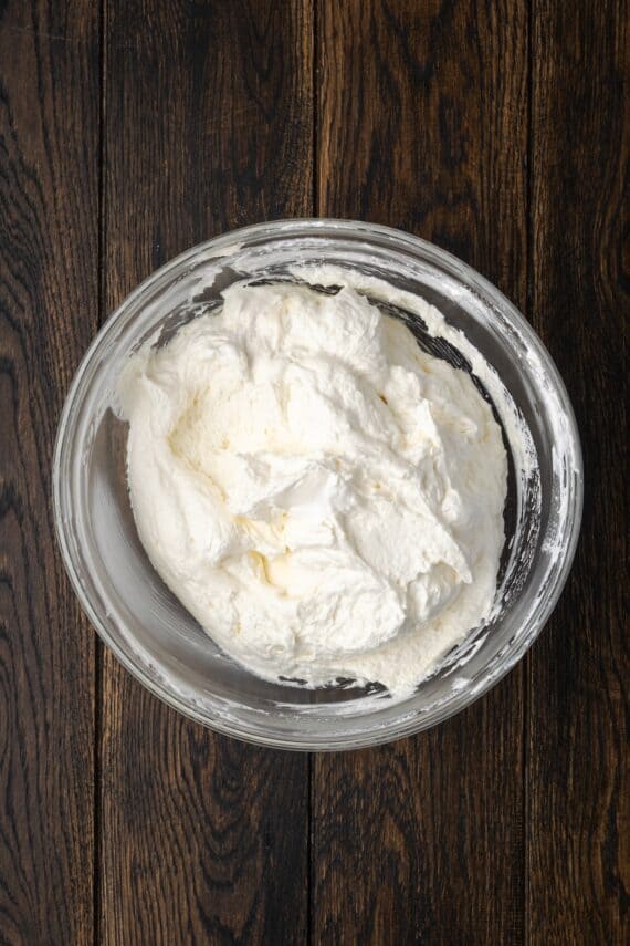 Cheesecake dip in a glass mixing bowl.