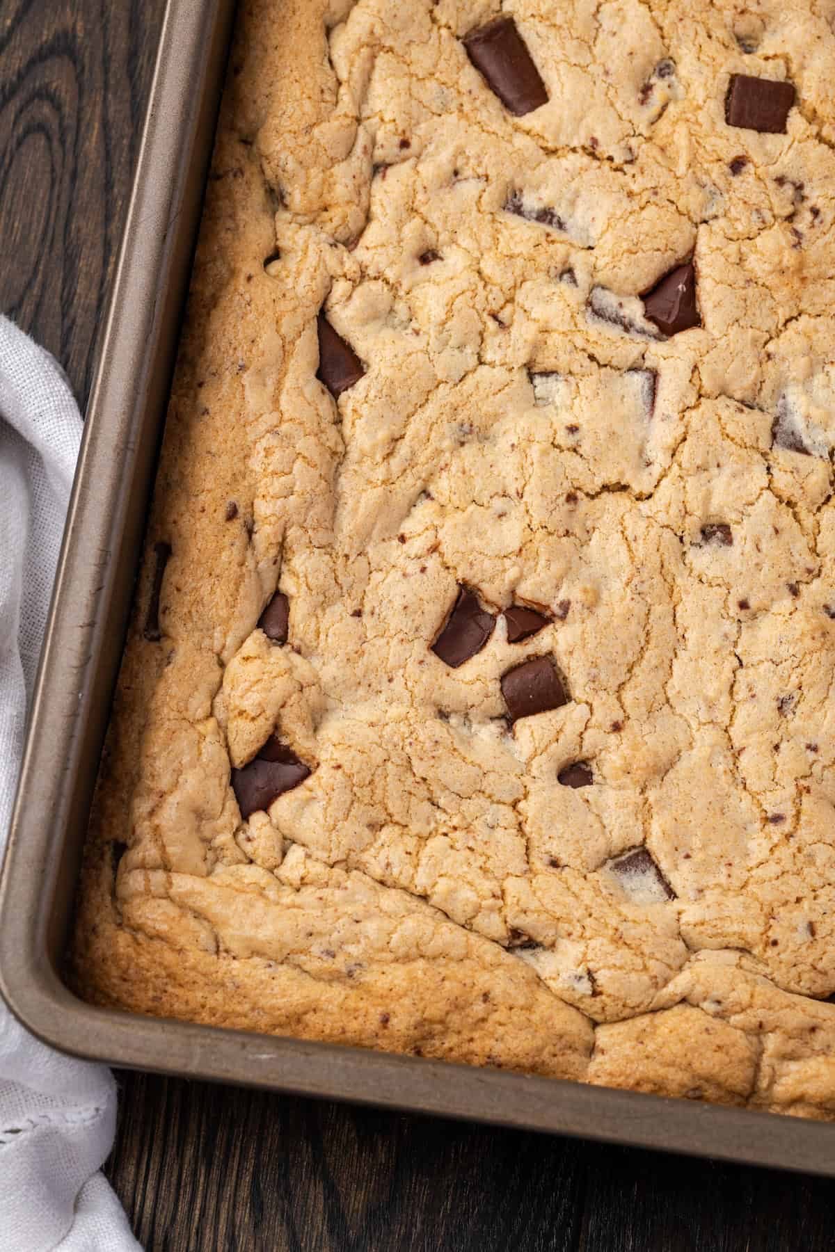 Overhead view of chocolate chip cookie bars inside a baking pan.