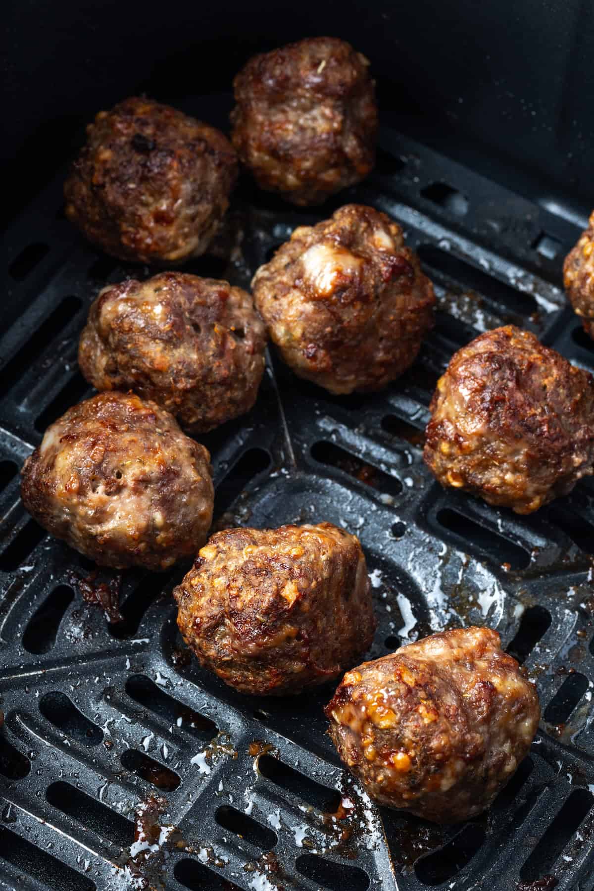 Cooked meatballs inside the air fryer.