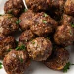 Air fryer meatballs piled on a white serving platter.