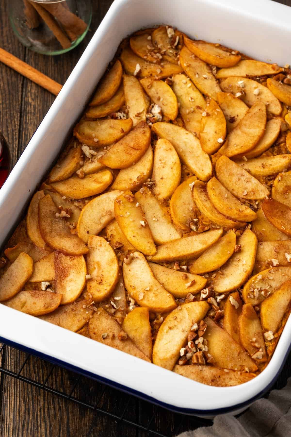 Overhead view of baked pumpkin oatmeal topped with cinnamon apples in a baking dish.