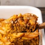 A slice of baked pumpkin oatmeal being lifted from a baking dish.