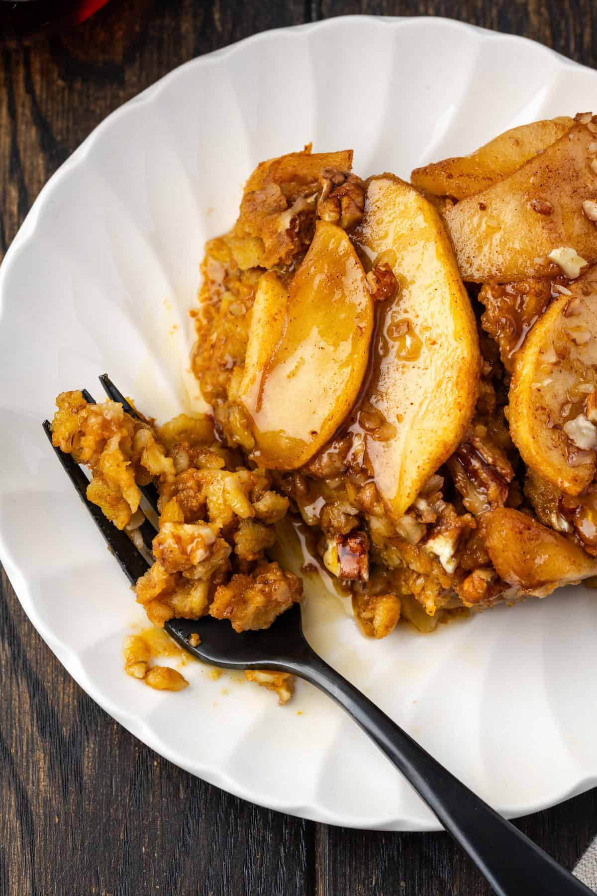 Overhead view of a slice of baked pumpkin oatmeal on a plate with a fork.
