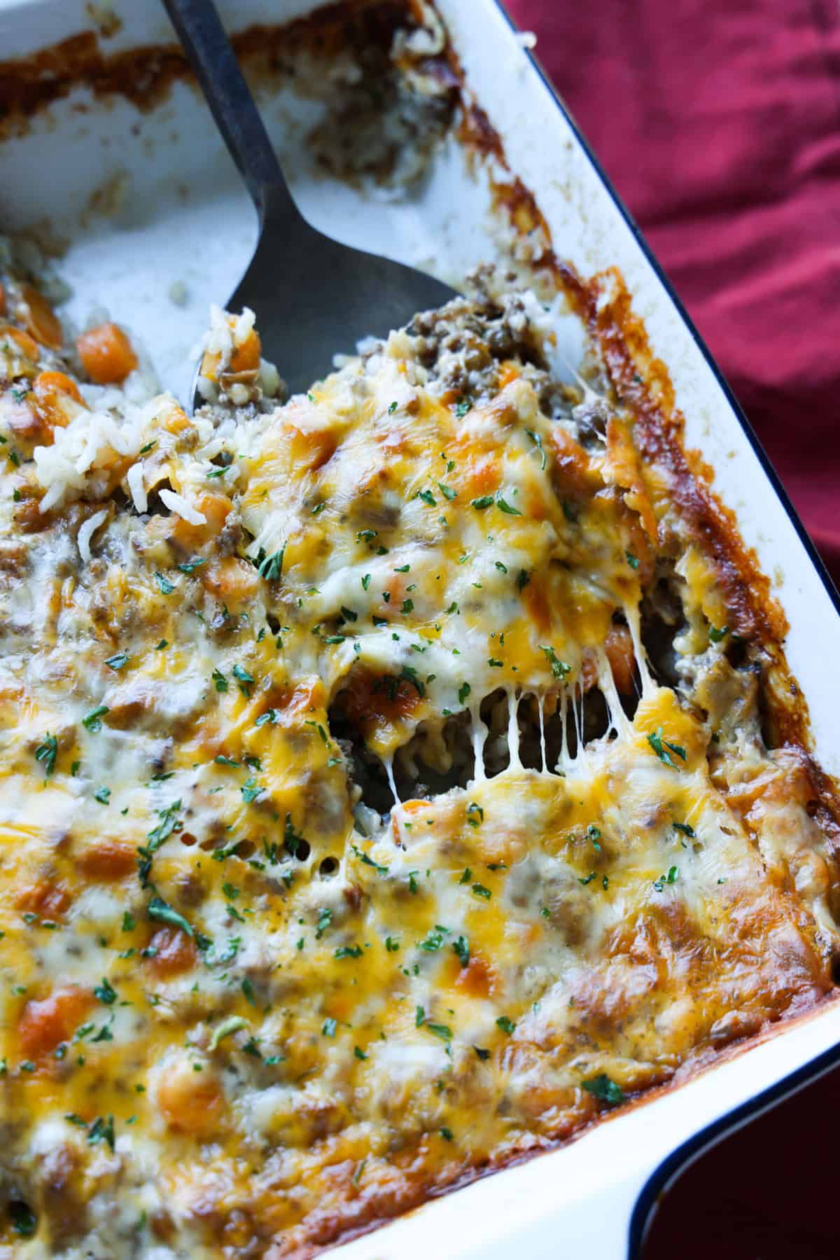 Rice and Ground Beef Casserole baked in a 9x9 pan topped with cheese