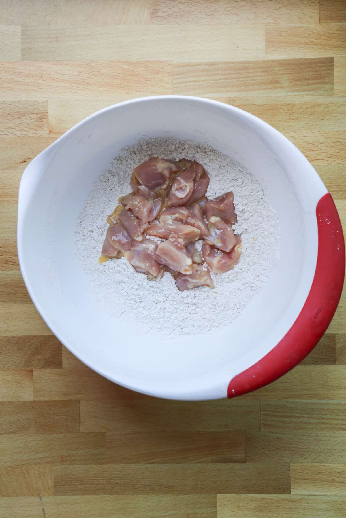 This copycat PF Chang’s spicy chicken recipe is a quick and delicious sweet and spicy stir-fry! Make it in one skillet and serve it with rice. Chicken pieces partially dredged in a bowl of flour mixture.