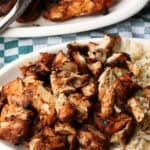 Chopped Chipotle chicken served next to rice on a plate, with more chicken on a second plate in the background.