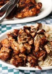 Chopped Chipotle chicken served next to rice on a plate, with more chicken on a second plate in the background.