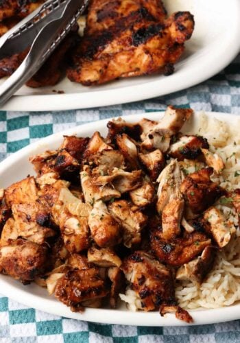 Chopped Chipotle chicken served next to rice on a plate, with more chicken on a second plate in the background.
